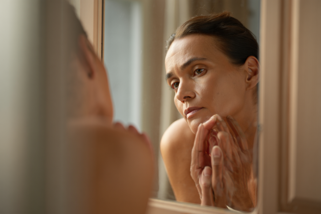 Женщина смотрит на своё отражение в зеркале: момент честной встречи с собой и принятия реальности