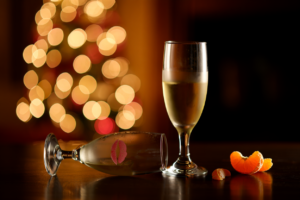 два бокала шампанского на фоне праздничных огней — один нетронутый, тихое одиночество в праздник